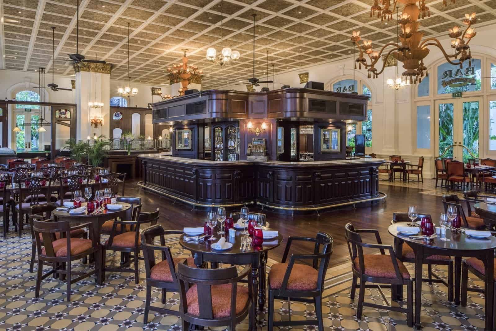 Elegant hotel restaurant interior with vintage decor, chandeliers, and stylish seating.