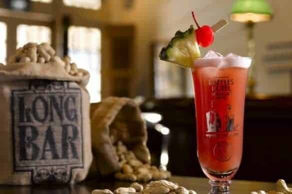 Refreshing tropical cocktail garnished with pineapple slice and cherry.