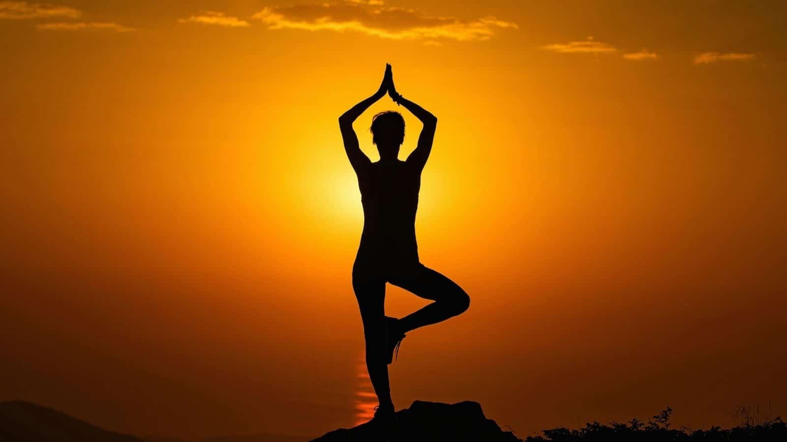 Person practicing yoga at sunset