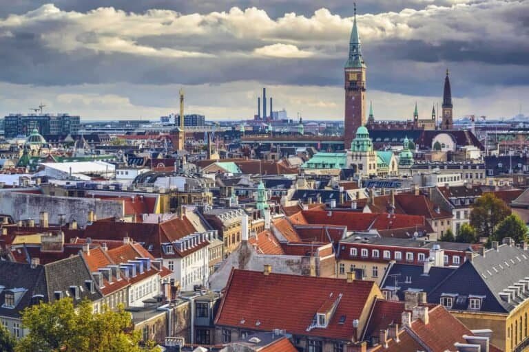 Copenhagen rooftops and City Hall tower under a dramatic sky